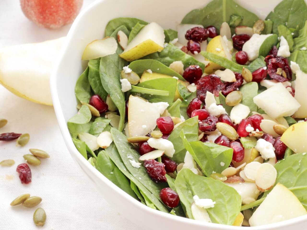 Tart pomegranate arils and dried cranberries, nutty almond slivers and pumpkin seeds, sweet chunks of Bartlett pears and salty feta cheese combine over earthy spinach leaves for a beautiful fall salad.