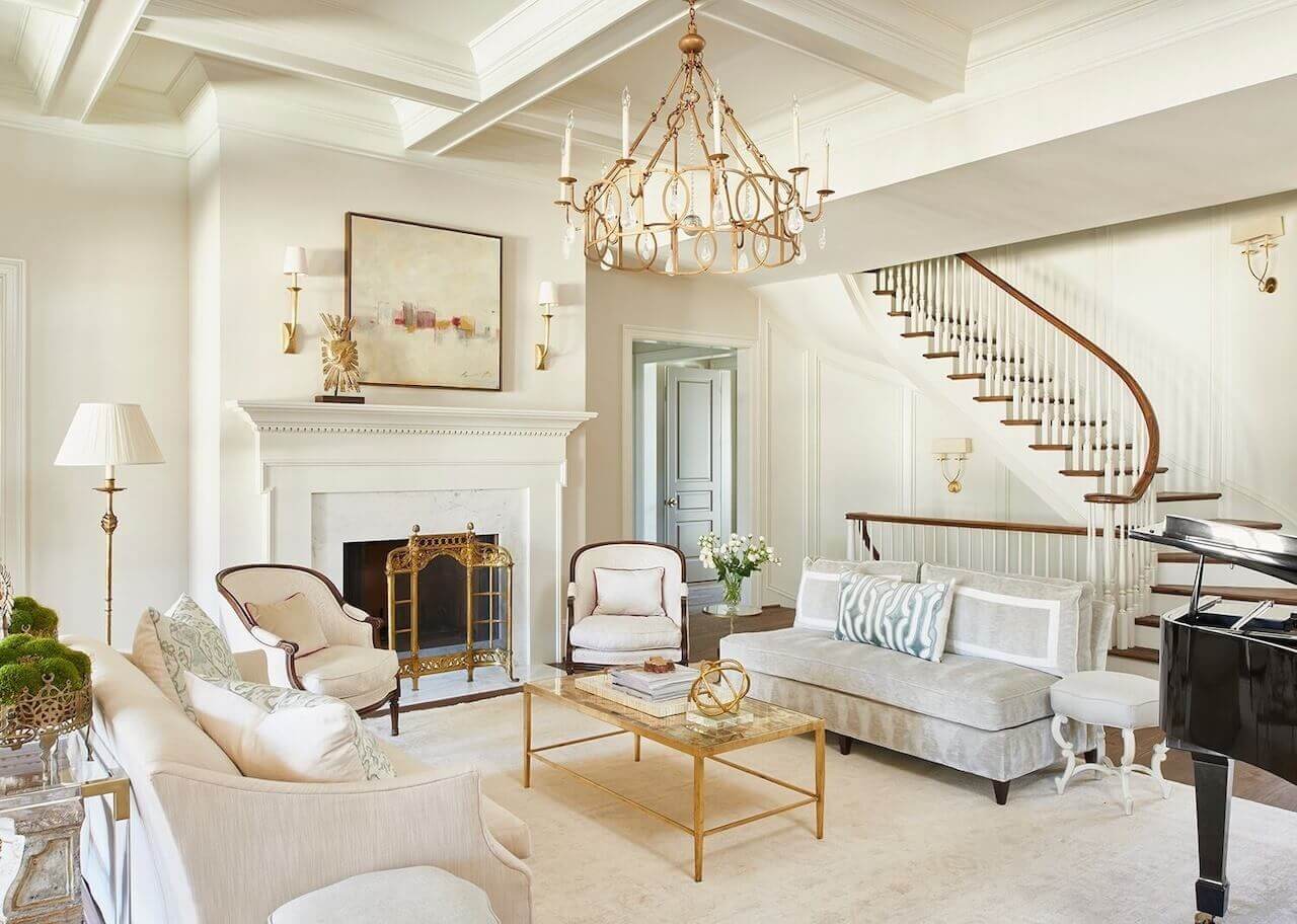 Designer Lyndsy Woods painted the living room walls Benjamin Moore York Gray (tinted at 50% strength) and the trim Benjamin Moore White Dove as a crisp backdrop for traditional furnishings. A custom light fixture from Solaria Lighting picks up curvilinear shapes elsewhere in the house.