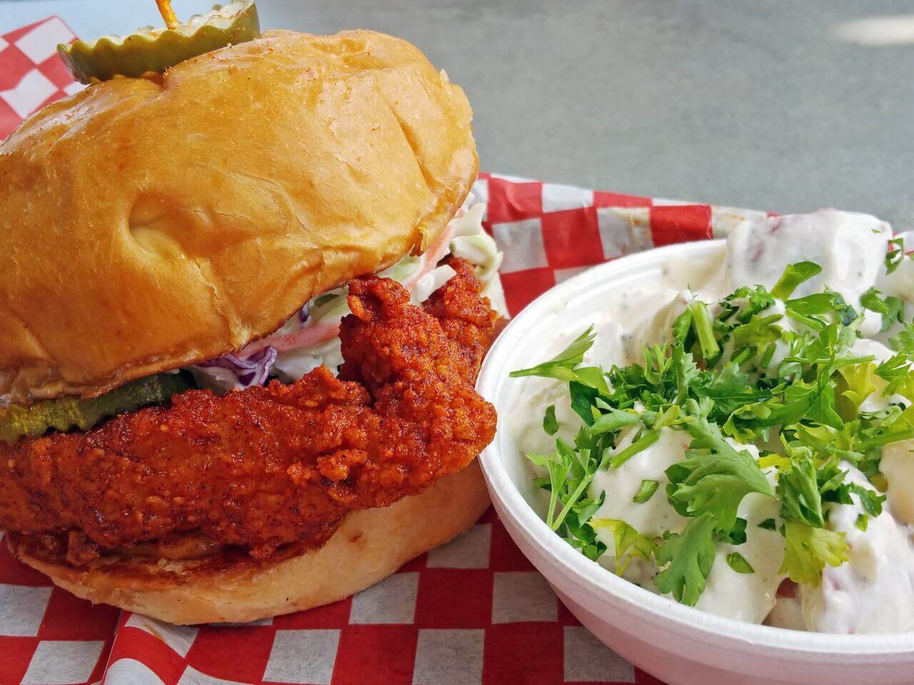 The Hattie B's hot chicken mouthwatering sandwich pairs perfectly with the house potato salad.
