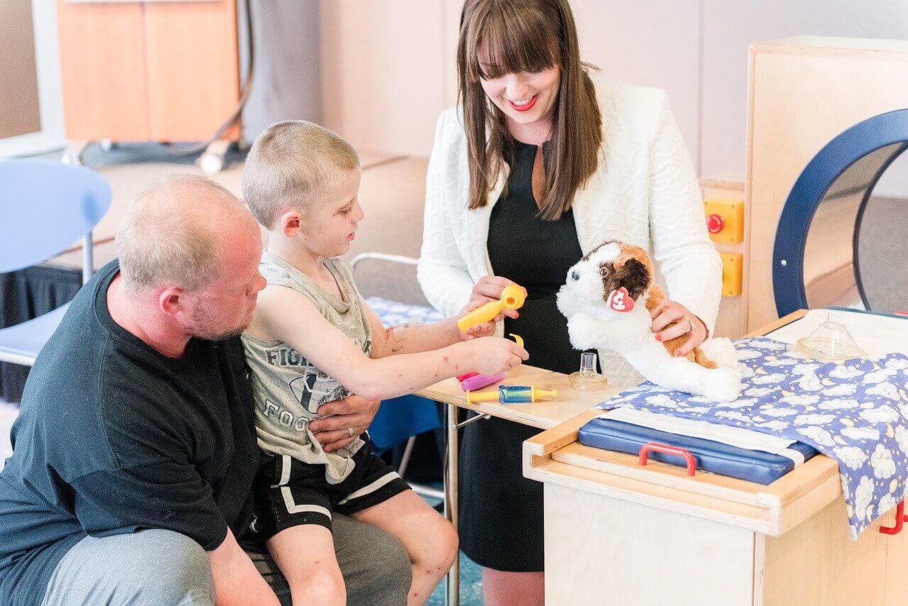 Chandler helps a pint-sized patient doctor up a stuffed animal.