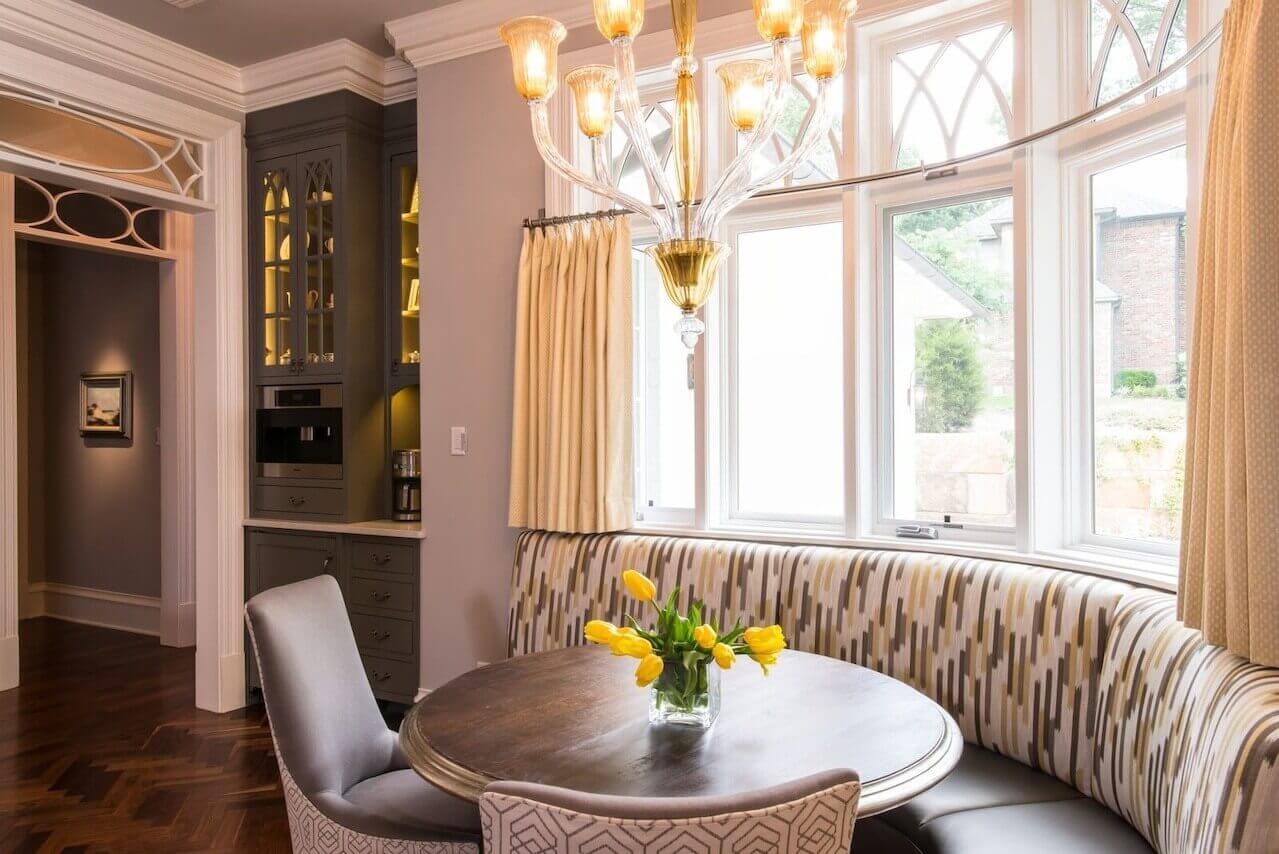 Mitchell Gold chairs with a lively fabric on the back add to the charm at the curvy seating area. A built-in Miele coffee machine is nearby.