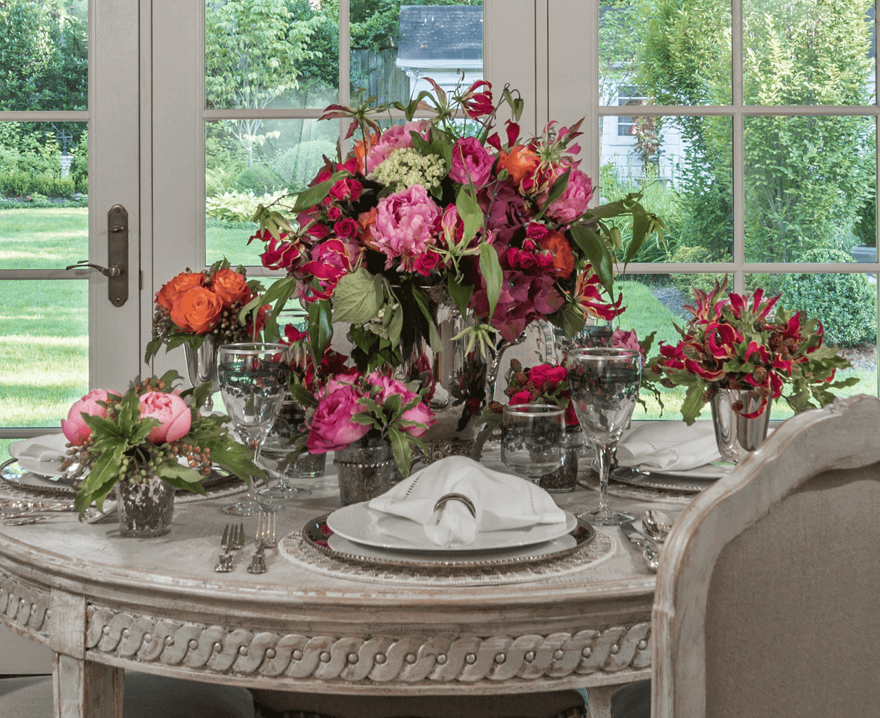 A cherished set of crystal stemware was selected for the table, because its purple-blue etched floral design effortlessly unites the flowers with the tableware in a delicate and chic style.