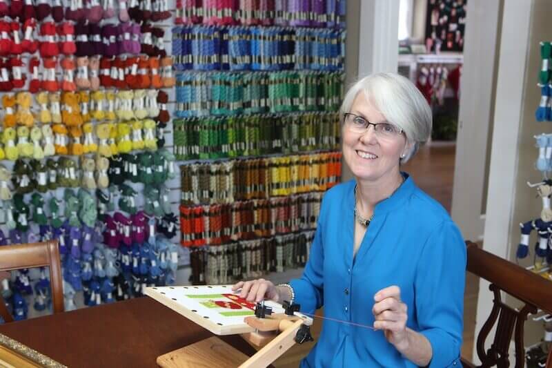 Judith Carter, owner of Needleworks, works on a holiday-themed needlepoint piece. Judith Carter, owner of Needleworks, works on a holiday-themed needlepoint piece.