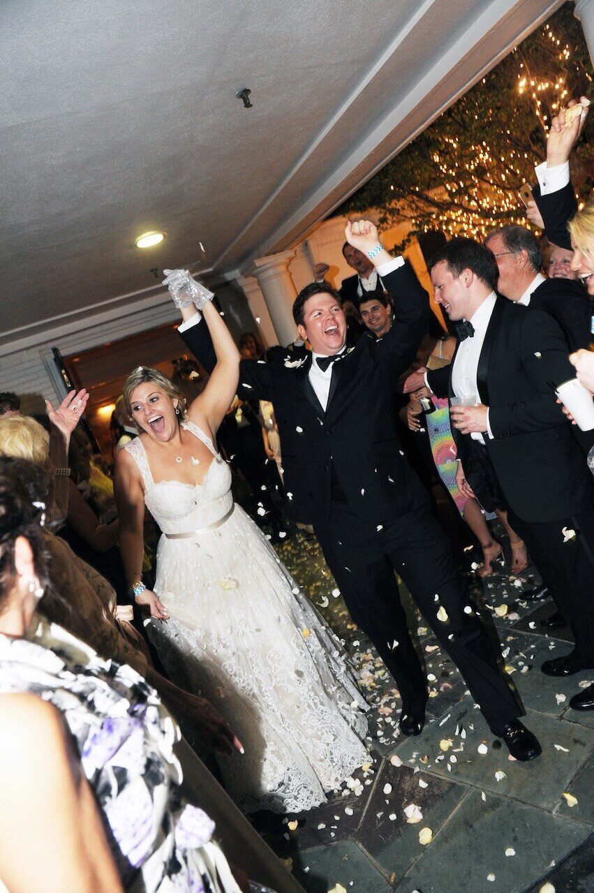 Guests sent the couple off with a shower of white rose petals.