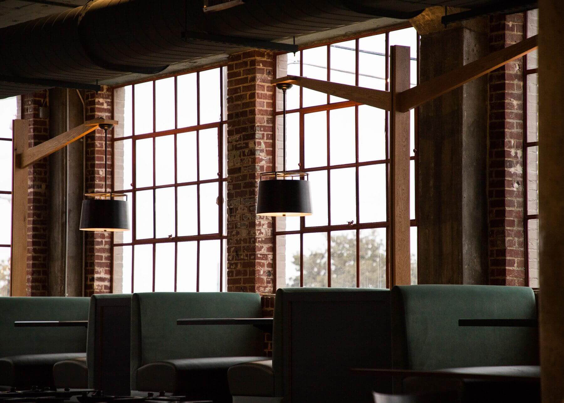 Booths line a wall of 100-year-old warehouse windows overlooking the Mississippi River. The Gray Canary