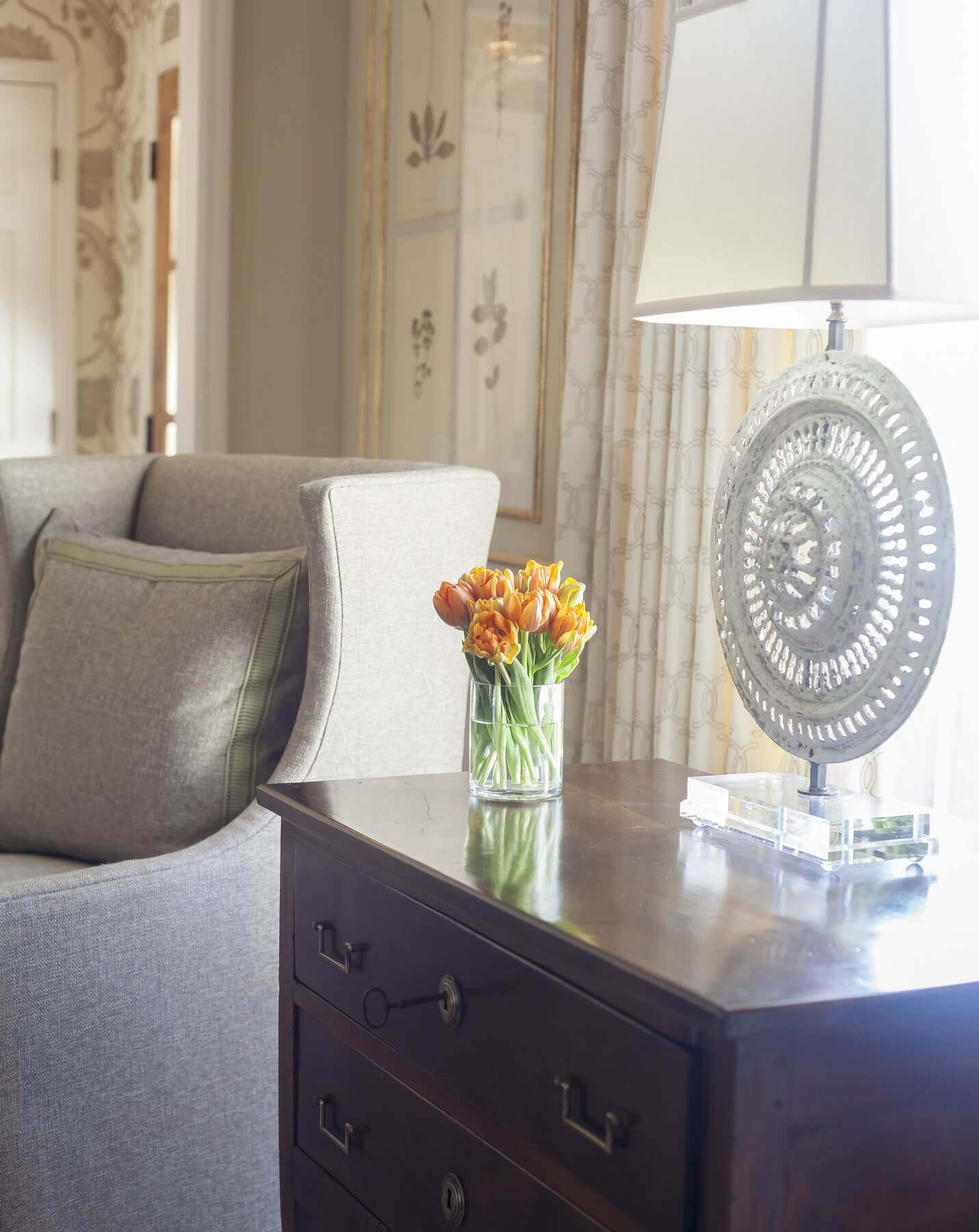 Cindy used artwork and accent pieces, like this unique traditional-meets-modern lamp, to add texture and interest while keeping with the home’s overall neutral palette. Tailored draperies and clean-lined wingback chairs bring a crisp, yet casual vibe. Cindy McCord