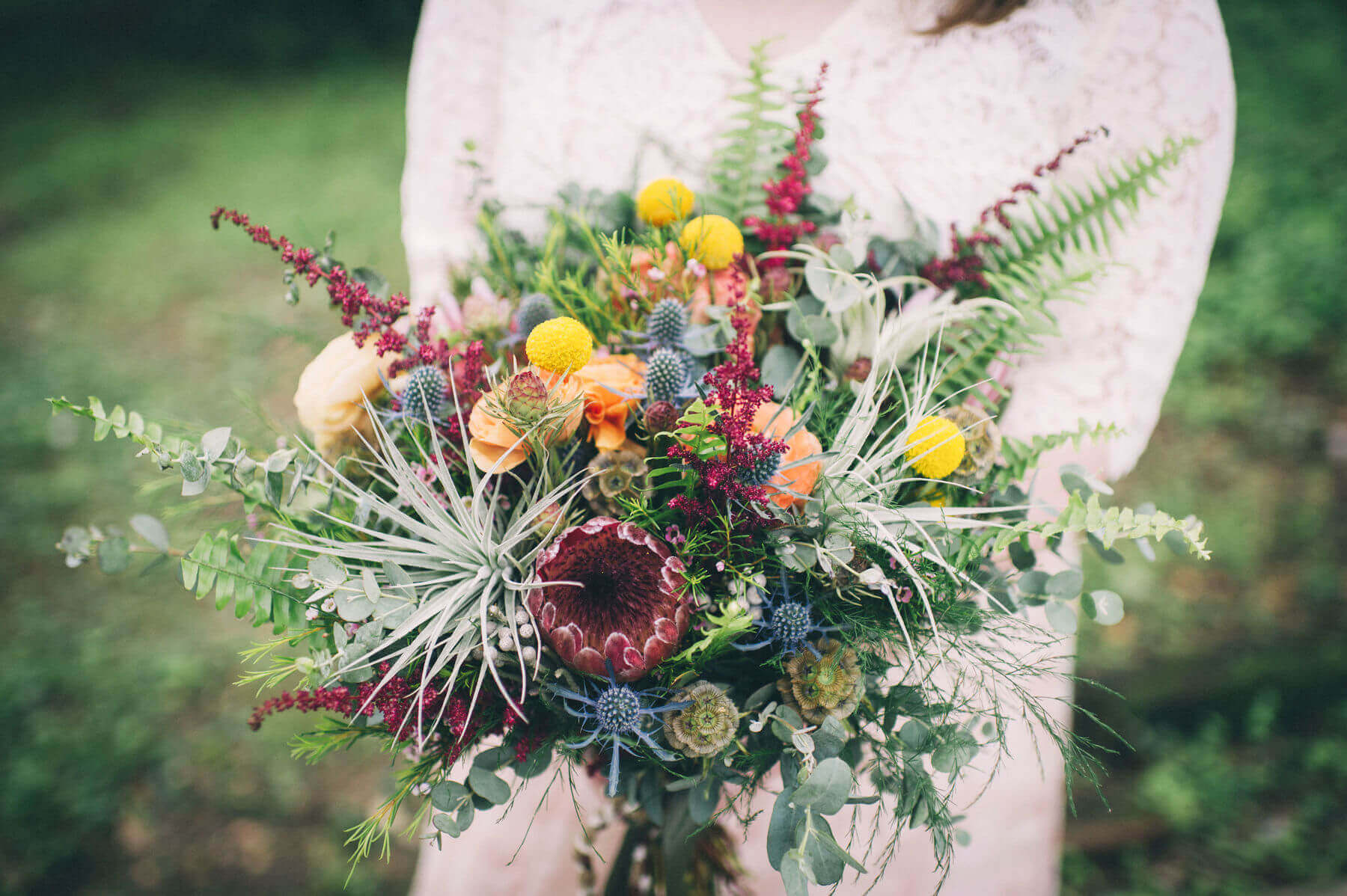 Jessica’s bouquet by Blooms is utterly jaw dropping. “I knew I wanted it to be big and wild, with lots of greenery and pops of color,” Jessica says. Sprawling fern fronds and eucalyptus give the bouquet that gathered, organic look Jessica envisioned, with a dramatic king protea bloom, pops of bright yellow craspedia, and thistle, succulents and air plants to add texture and color. treehouse elopement