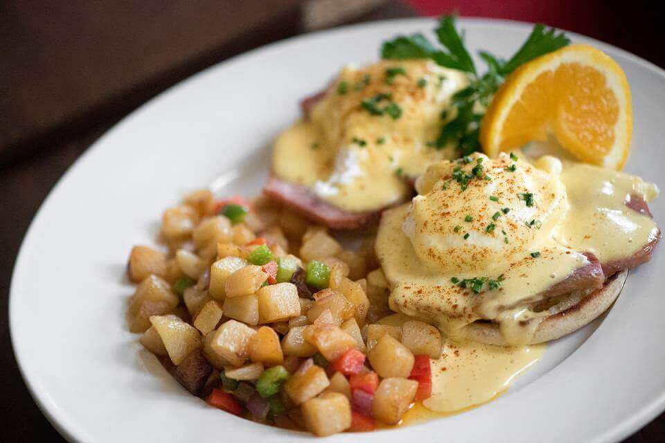 Plated eggs Benedict with diced potatoes