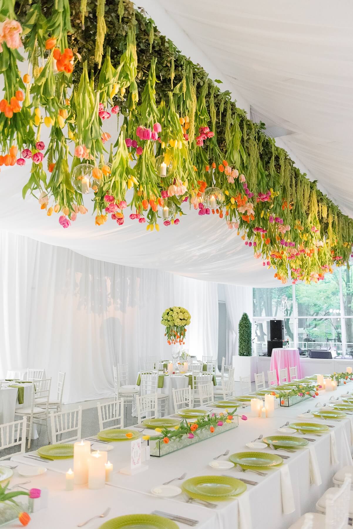 Vibrant tulips seem to grow from the ceiling above the reception space, an idea from Hothouse Design Studio that perfectly captured Ashley’s modern, colorful aesthetic.