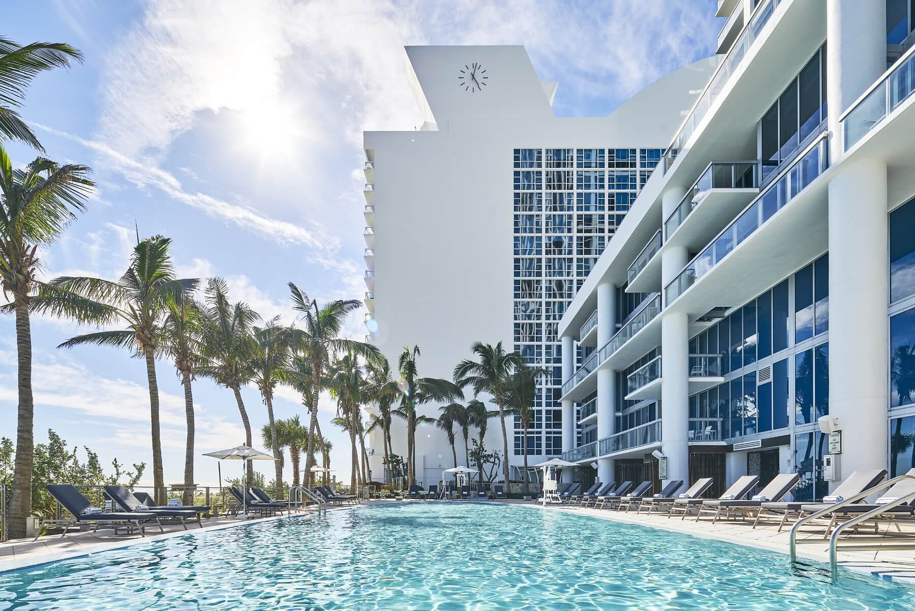 A pool next to palm trees at a resort