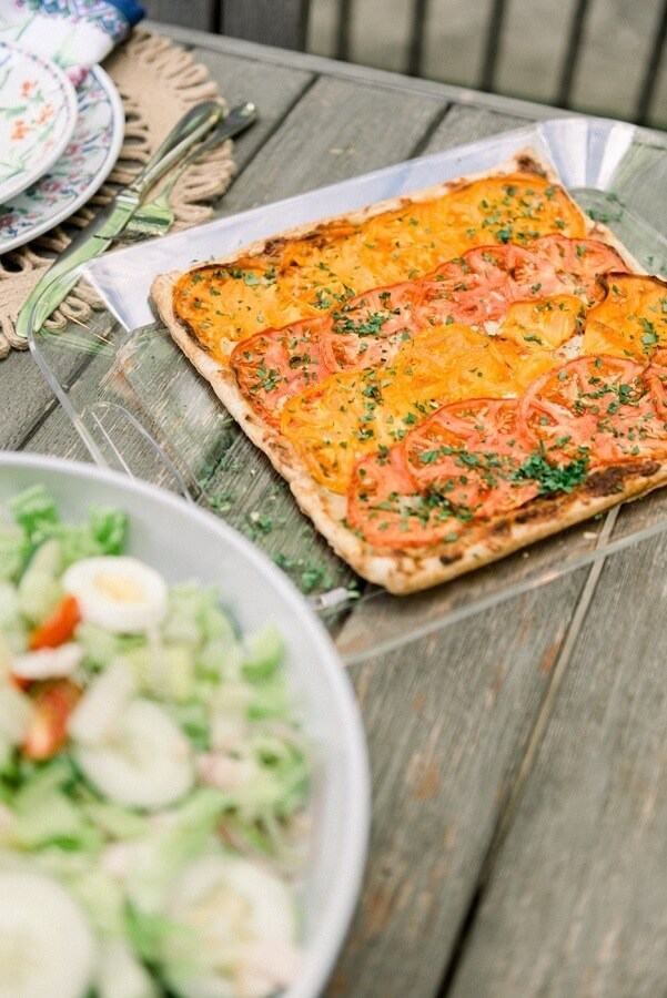 Ashley Mac's local tomato tart features freshly sliced tomatoes, italian cheeses, a homemade spread of caramelized onions and fresh herbs all baked on a flaky crust. Yes, please! Ashley Mac's local tomato tart features freshly sliced tomatoes, italian cheeses, a homemade spread of caramelized onions and fresh herbs all baked on a flaky crust. Yes, please!