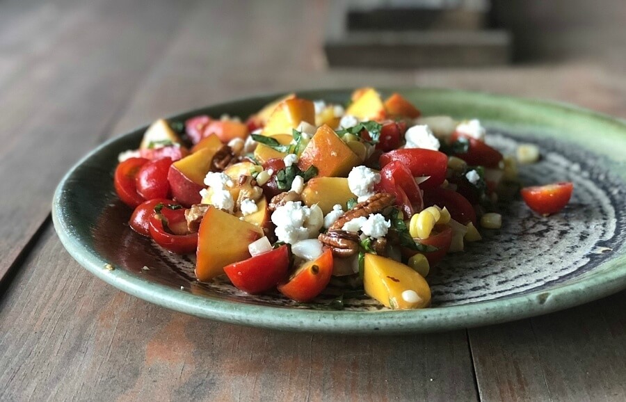 Ceramic plate with peach and tomato salad