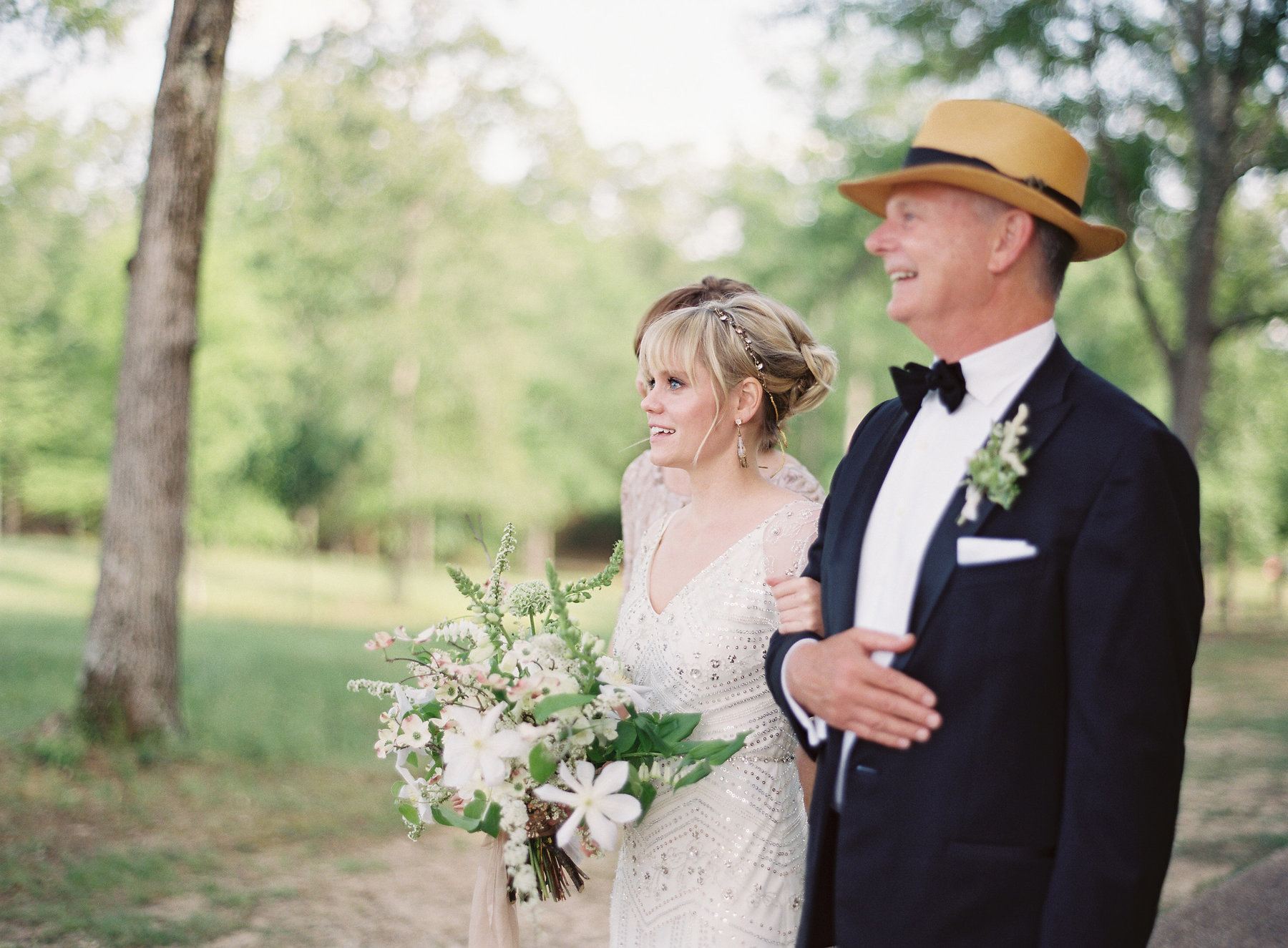 Marie looks down the grassy aisle towards her groom in complete wonderment.