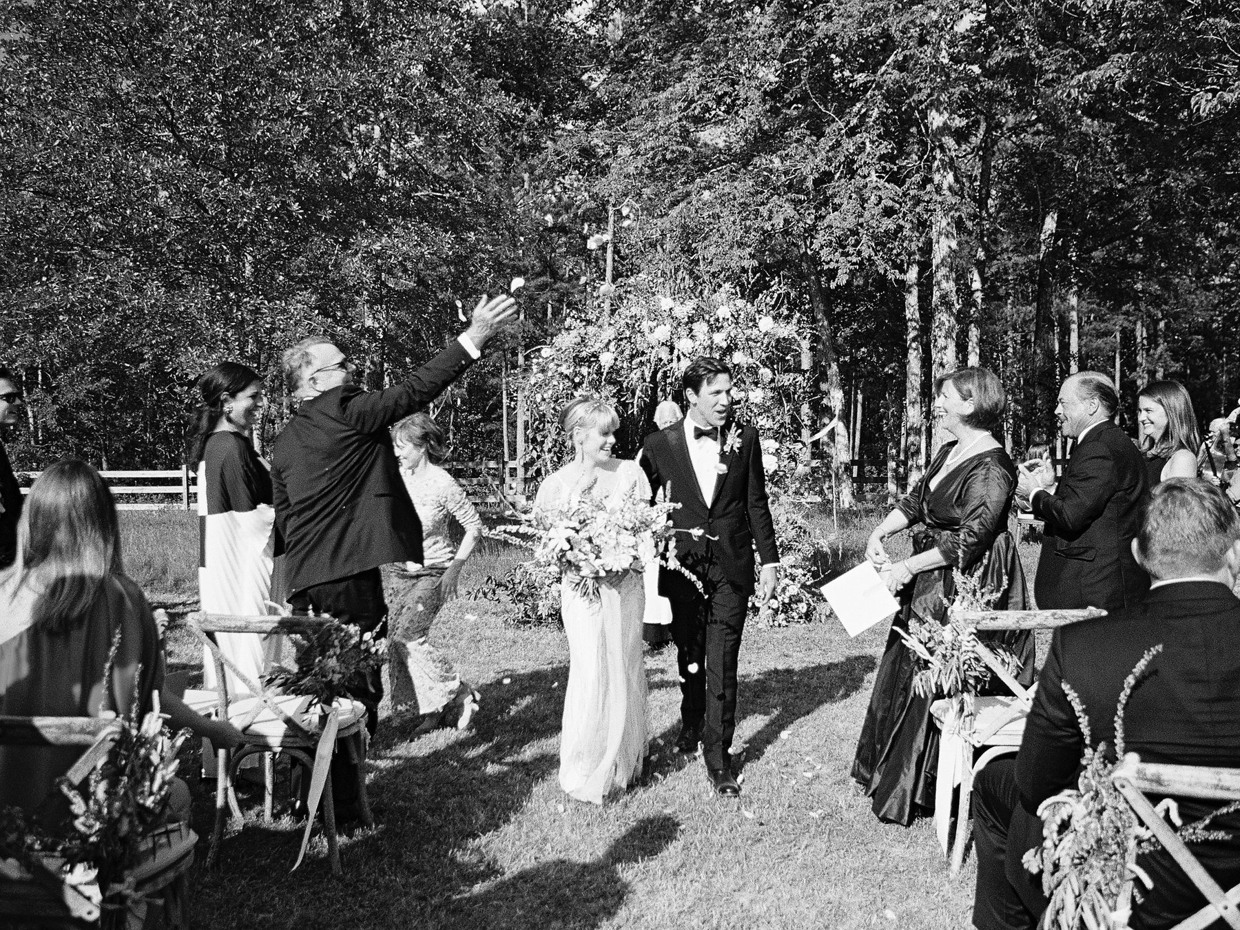 The happy couple walk down the aisle under a shower of flower petals.