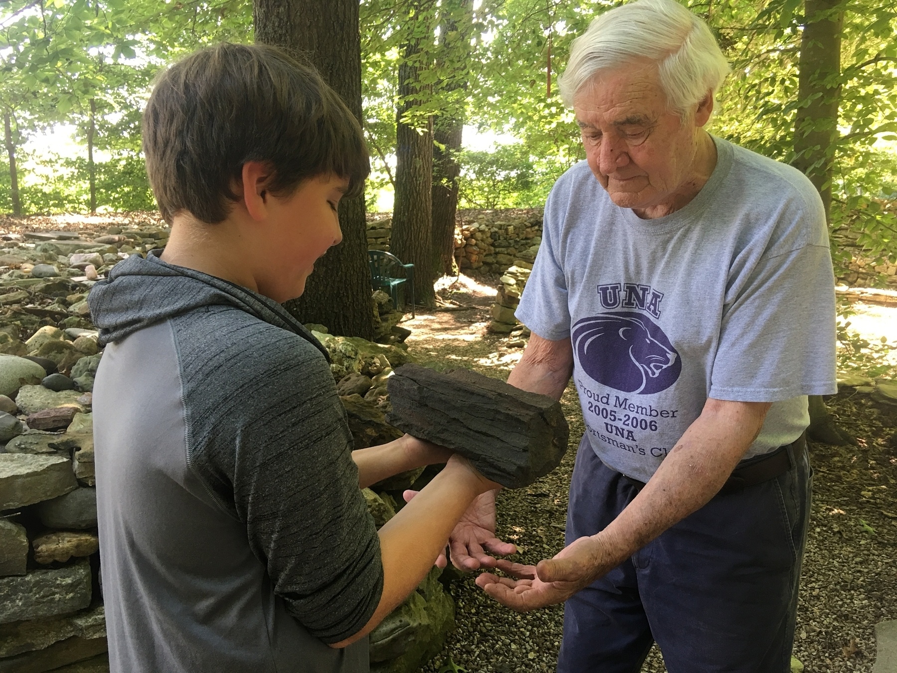 Tom, who has since passed away, showing a visitor a piece of petrified wood