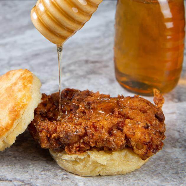 A chicken biscuit drizzled in honey from Rise Biscuits Donuts