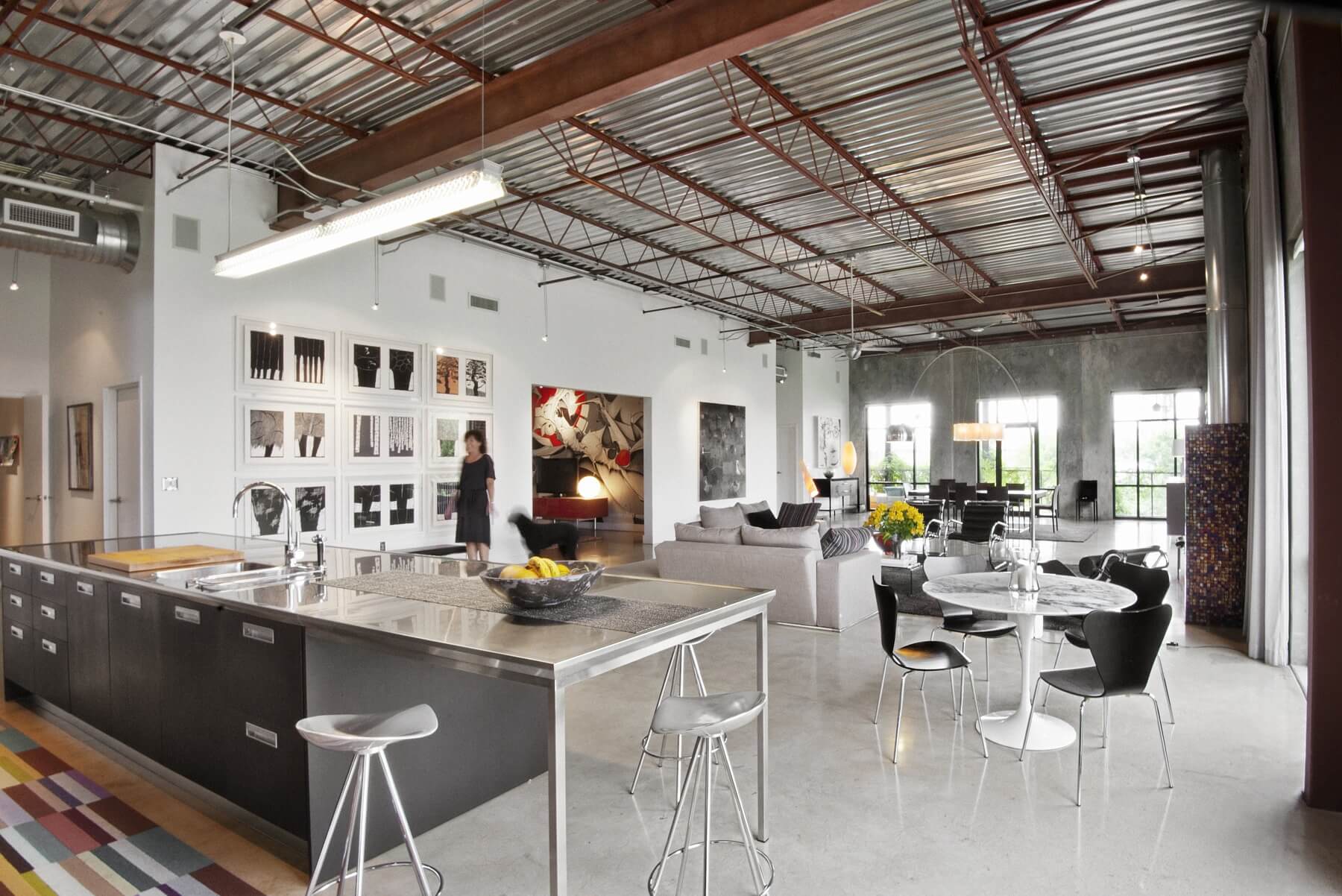 Metal is a through-line in this stunning loft space, accented by bright pops of color in furniture and modern art. Image: Liesa Cole at Studio Goodlight
