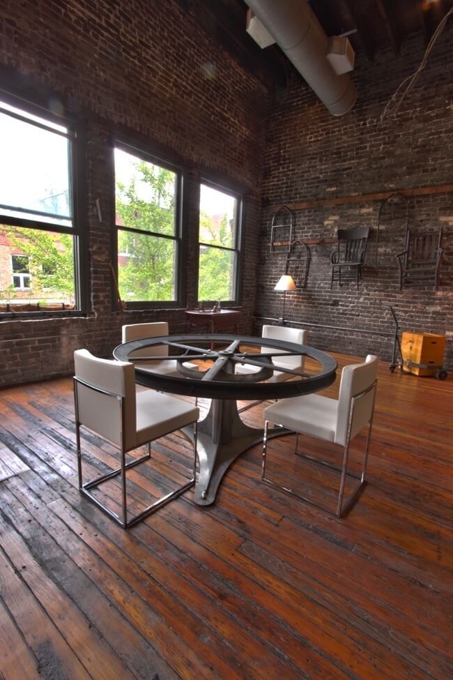 A wall of windows lets natural light flood the space. Repurposed items serve as functional furniture and wall art. Image: Creature