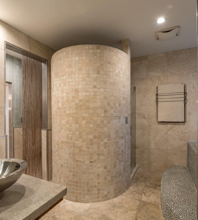 Eliza incorporated curved lines and walls throughout for visual interest. The master bathroom features a Jacuzzi tub, walk-in shower, dual sinks and heated towel racks. A sound system was also installed throughout the home so Elisa could enjoy music in every room. Image: Alan Bates