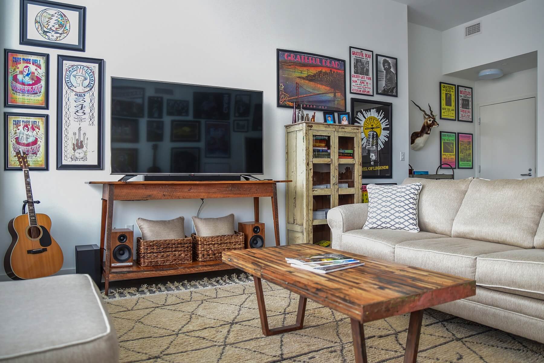 Vibrant concert posters and rustic wooden furniture mixes with modern furniture and a vintage rug for a look that teems with personality. Image: Mindy Rohr