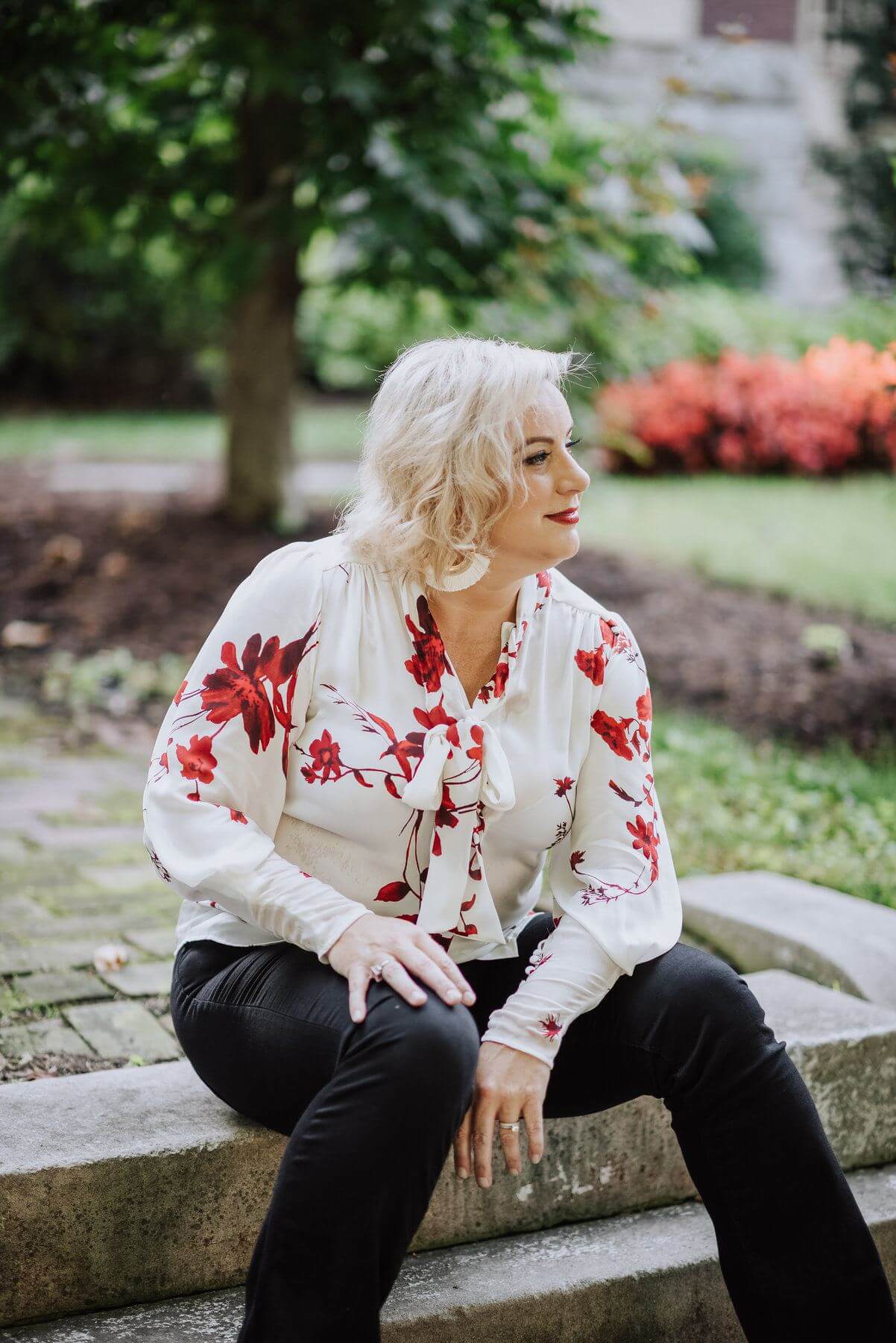 On Jessica from Rodes: White and red floral top, $298 | From Six Sisters: black flare jeans, $84 what to wear to october events in louisville