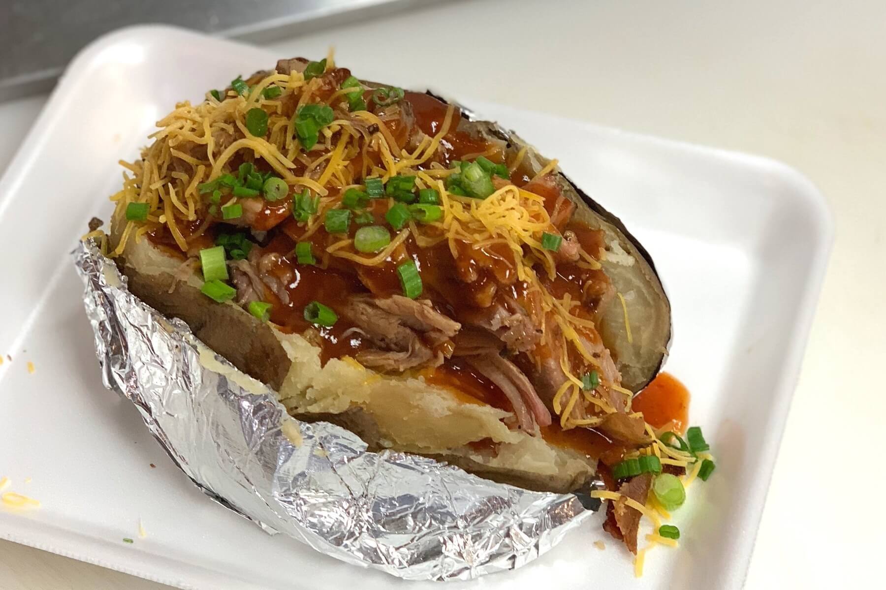 SAW's pork-stuffed tater with all the fixin's is the best kind of gut bomb. Image: SAW's