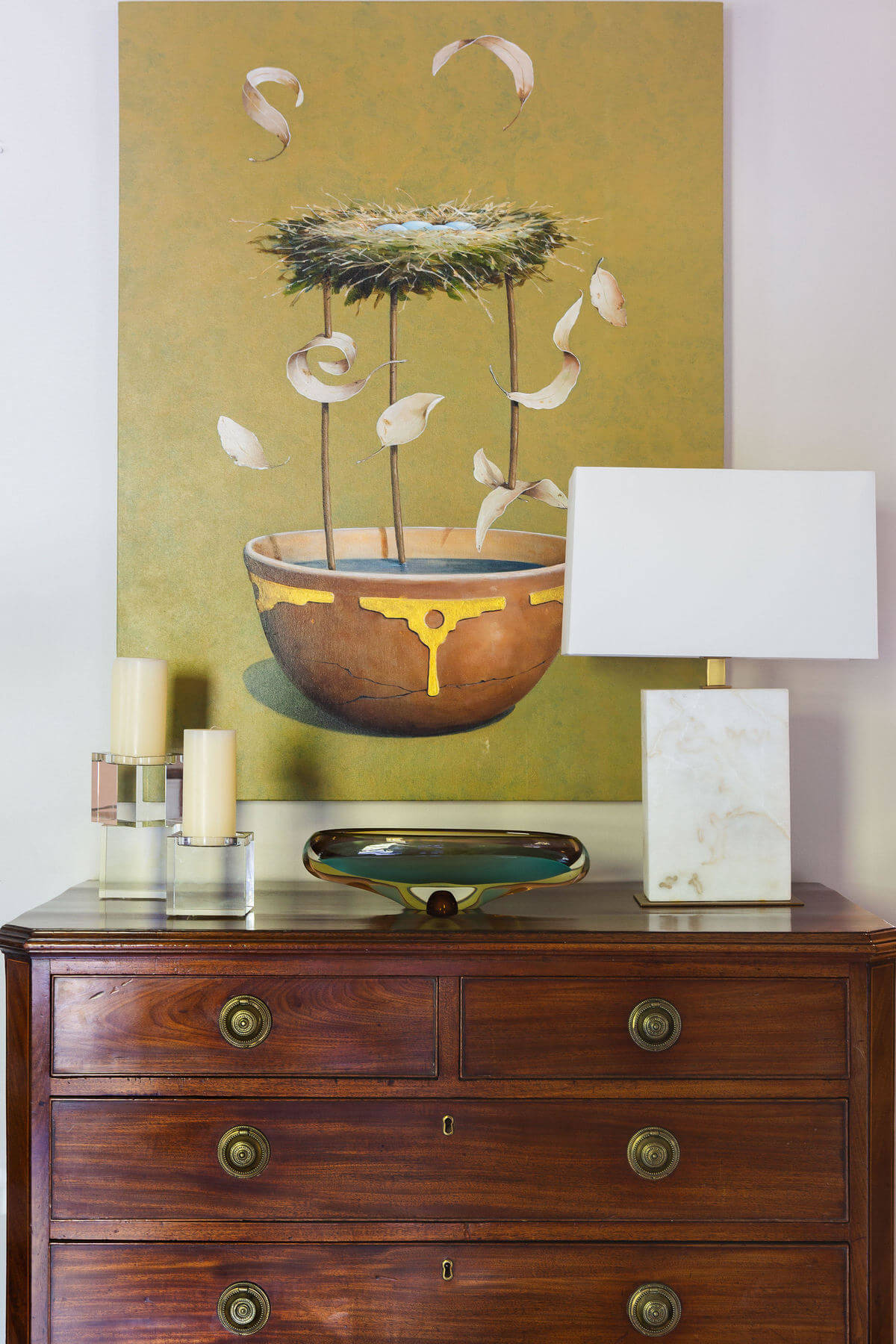 A bird’s nest painting by Nashville artist Jeff Faust hangs above an English antique chest in the entry hall, making a striking statement as soon as guests enter the gracious space. A bird’s nest painting by Nashville artist Jeff Faust hangs above an English antique chest in the entry hall, making a striking statement as soon as guests enter the gracious space.