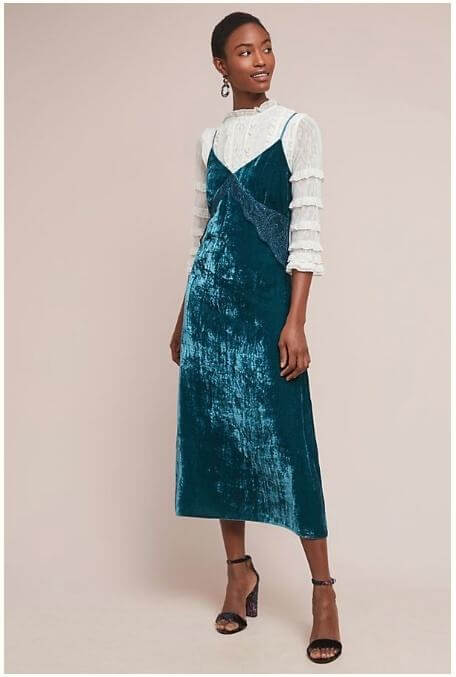 Eye-catching turquoise velvet, lace ruffle sleeves and statement earring make for a creative cocktail look that is sure to turn heads. Image: Anthropologie