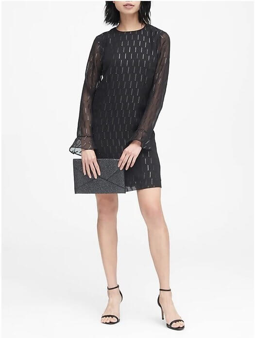 This dress doubles as a basic with personality-packed touches like the sheer ruffle-cuff sleeve and the subtle metallic pattern. Image: Banana Republic