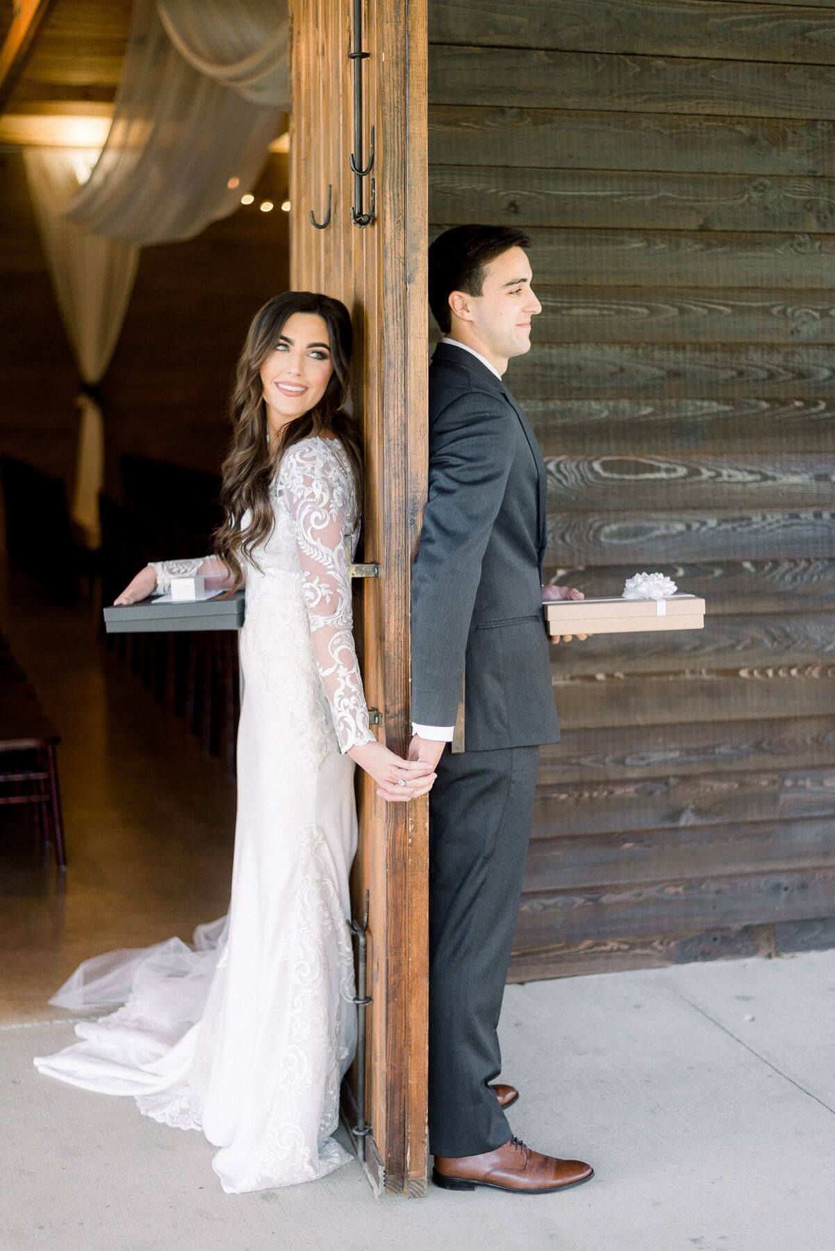 The lovebirds lock fingers before the first look, holding special wedding day gifts for one another. 