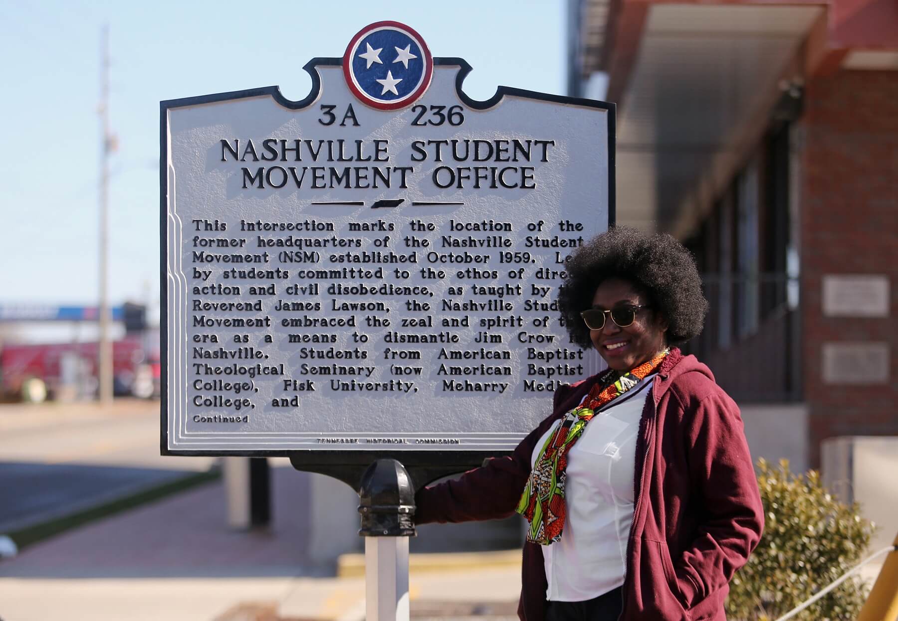 Chakita stands in front of a historic marker, which is just one stop on a United Street Tours walking tour.
