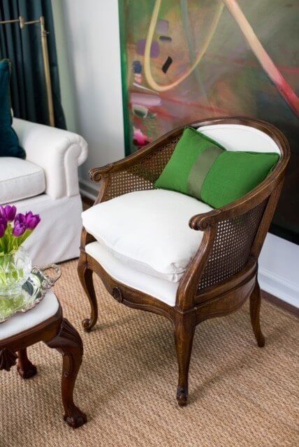 The classic lines of this cane-backed chair got an update with new white upholstery, and particularly looks striking against the abstract art. chair details