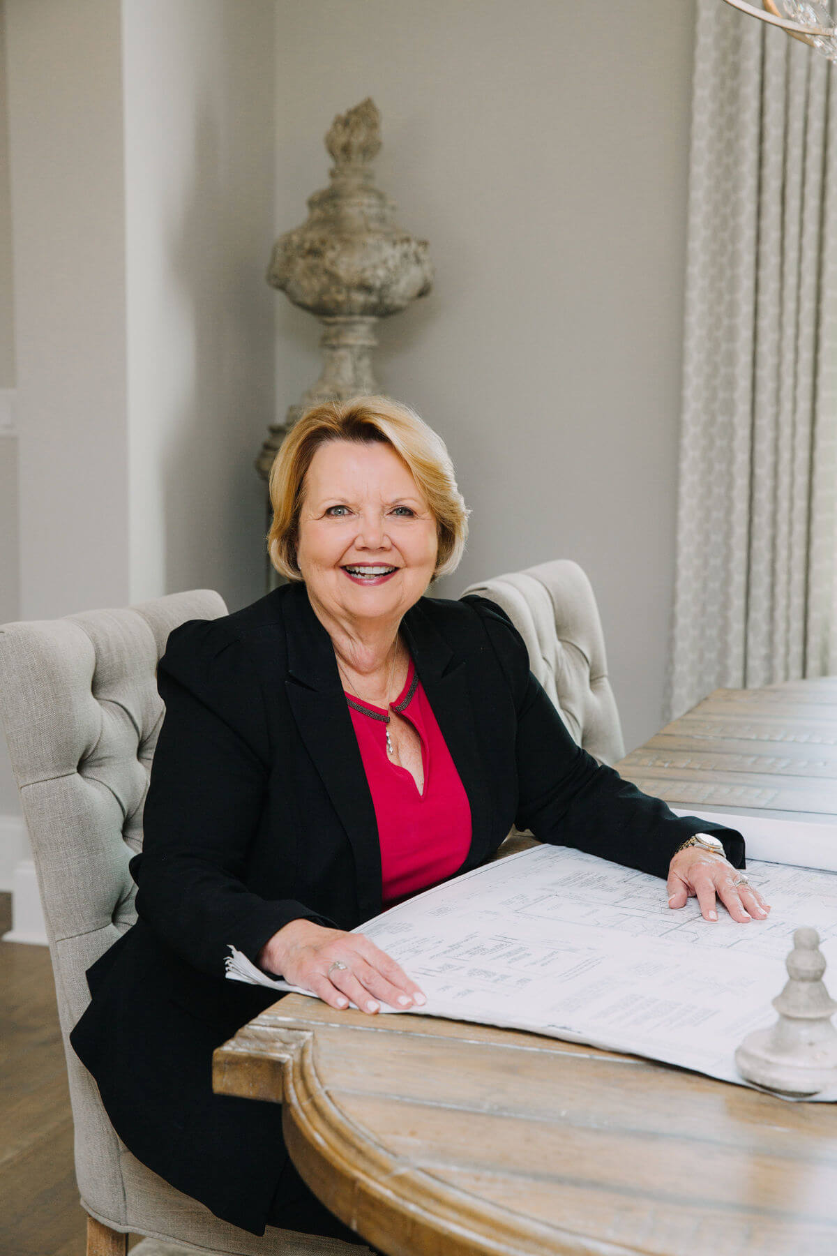 Karen Garner sits at a dining room table with a blueprint in front of her.