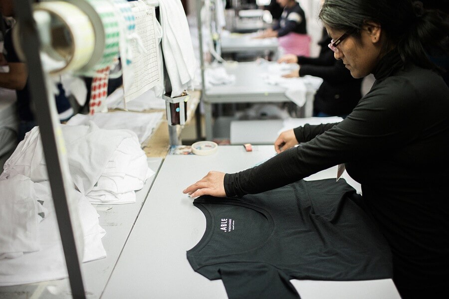 Here, an ABLE employee is cutting the cloth to make a t-shirt at their factory in Peru. ABLE publishes their wages, for even their lowest-paid employees, to transparently show that they are paying a living wage for all. It's fundamental to what this company believes in. "ABLE is a lifestyle brand focused on ending generational poverty by providing economic opportunity for women." ABLE employee- indigo t-shirt