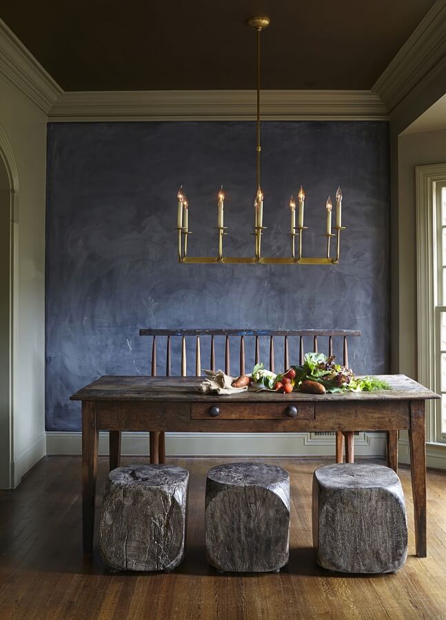 Aged wooden furniture suggests an Old World feel, but when juxtaposed by the modern chalk wall, the room becomes completely timeless. dining room design
