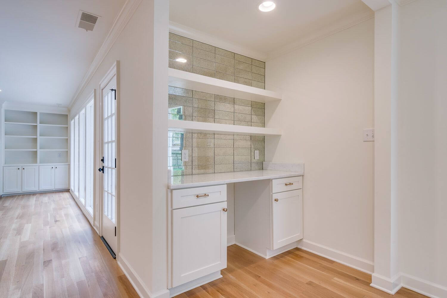 A mirrored backsplash brings interest to the bar area, an extension of the kitchen. Mirrored backsplash in Germantown renovation kitchen