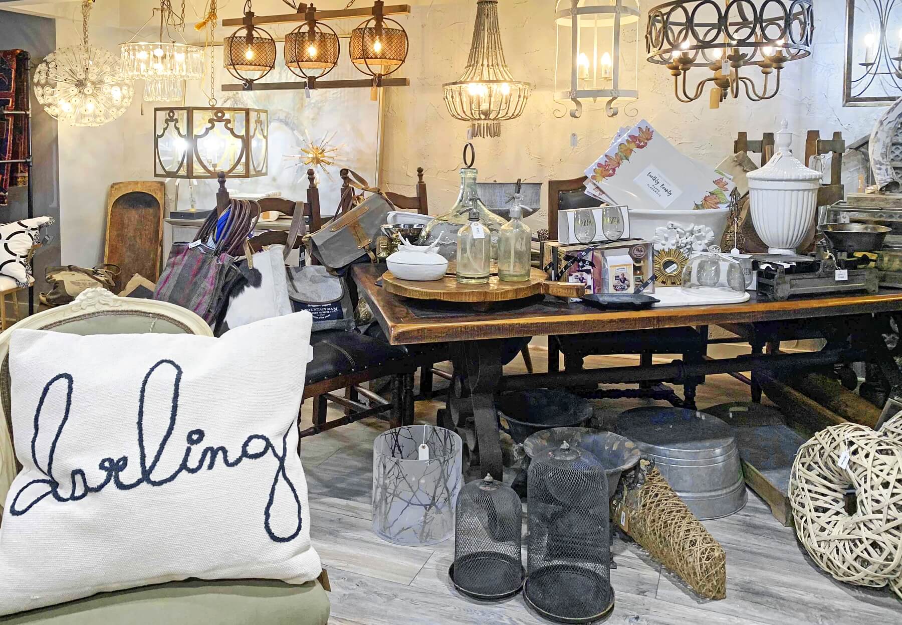 A beautiful assortment of furniture is upstairs, along with wall art, table decor, and cushions. The chandeliers are stunning, and you are sure to find a style that complements your home! chandeliers and furniture- Cotton Row Uniques