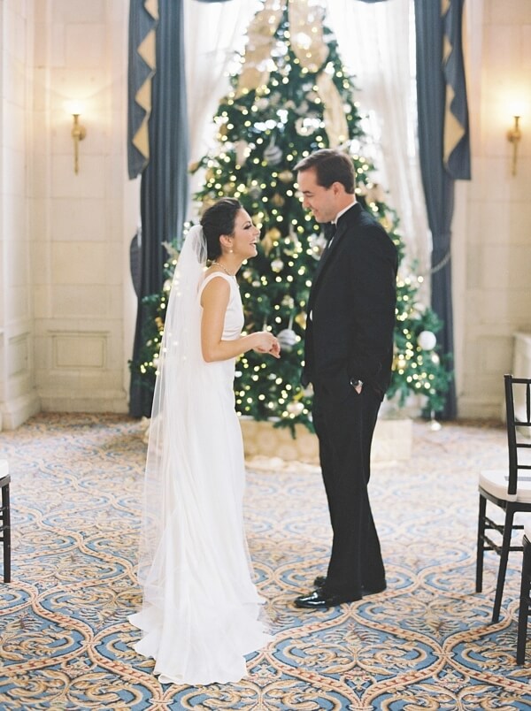 The bride and groom glow in the lights of the tree (and, perhaps, the excitement!). Bride and groom in front of the Christmas tree