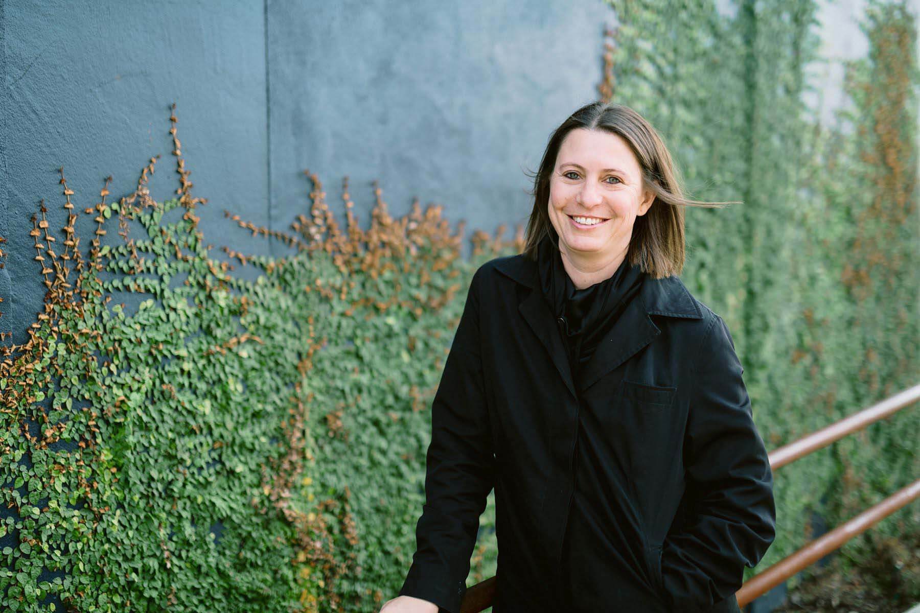 Director of Design & Development for Sloss Real Estate and today’s FACE of Birmingham, Callan Childs. Image: Eric & Jamie Photography Callan Childs in front of wall with greenery