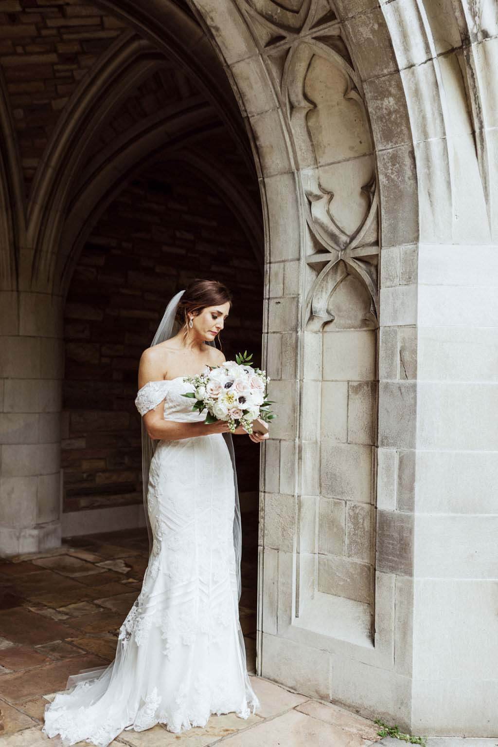 A dress blunder couldn't keep this bride from looking stunning in her gown! Here, she has a moment of reflection before first looks. first looks- bride with flowers- Southern hospitality wedding