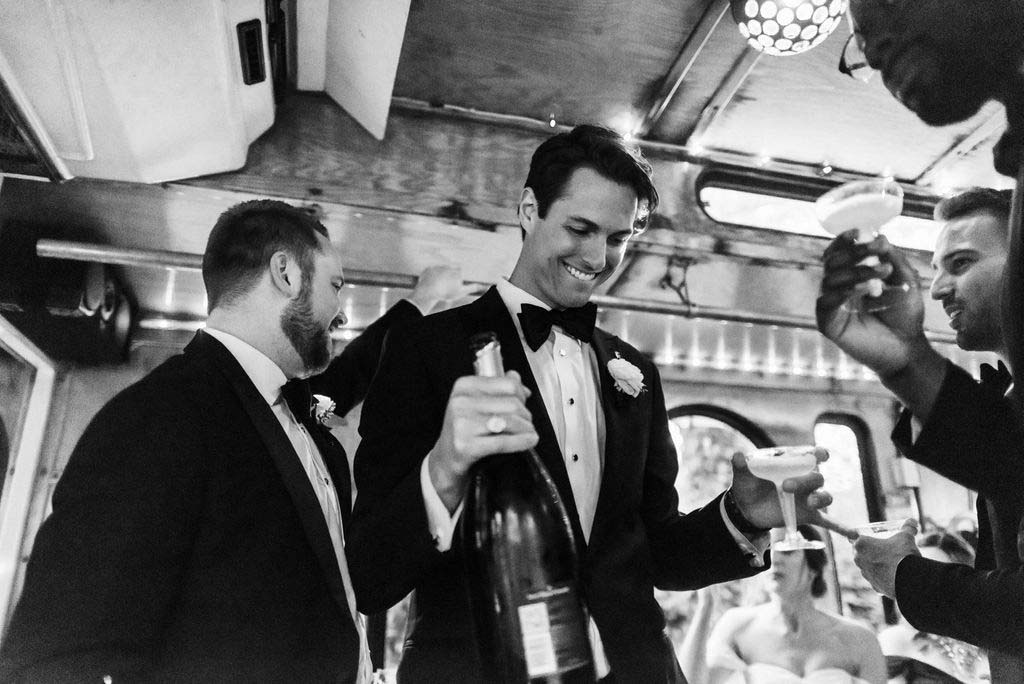 Dubbing one of their groomsmen the “captain of the trolley,” they bestowed him with a captain’s hat and put him in charge of the playlist. The champagne flowed, snacks were passed around, and the wedding party had much-deserved time to celebrate with the Bokers as they rode out to their reception at the Loveless café. groom with champagne in trolley headed to Southern hospitality wedding
