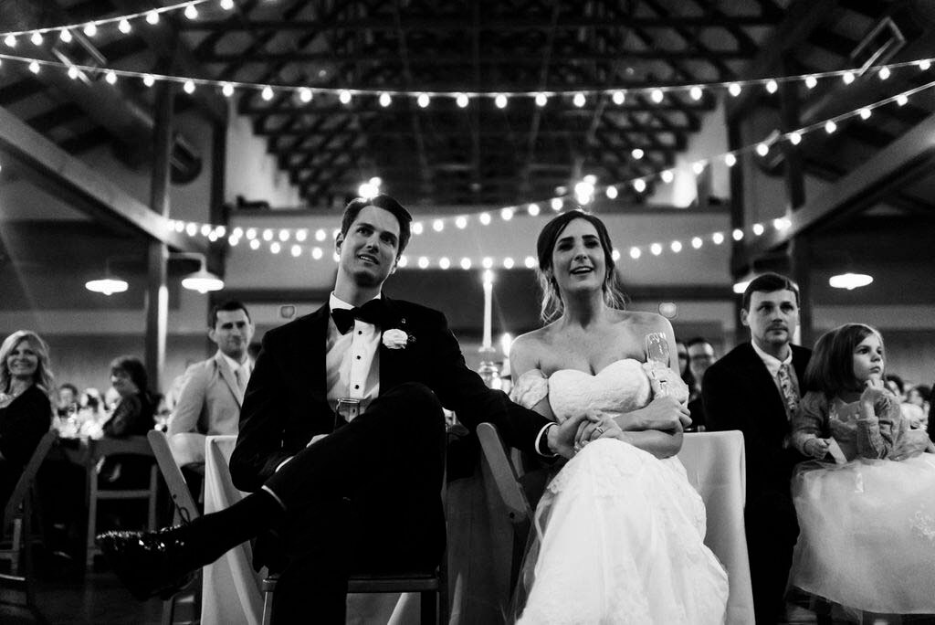 Their reception, held at the barn space at the Loveless Cafe, gave their wedding authentic Southern flair. bride and groom sit and watch reception