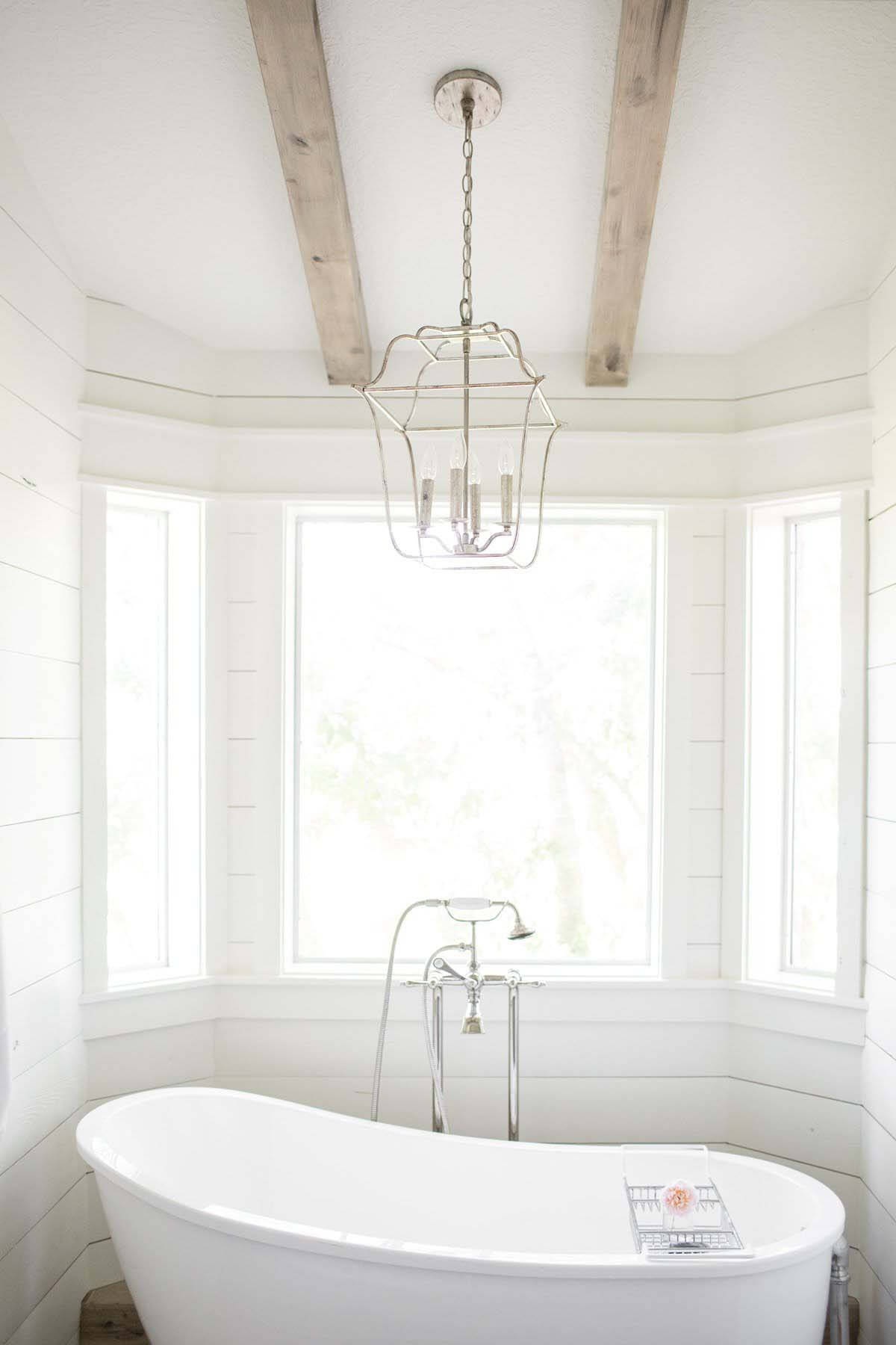Master bathroom with bathtub and beamed ceiling