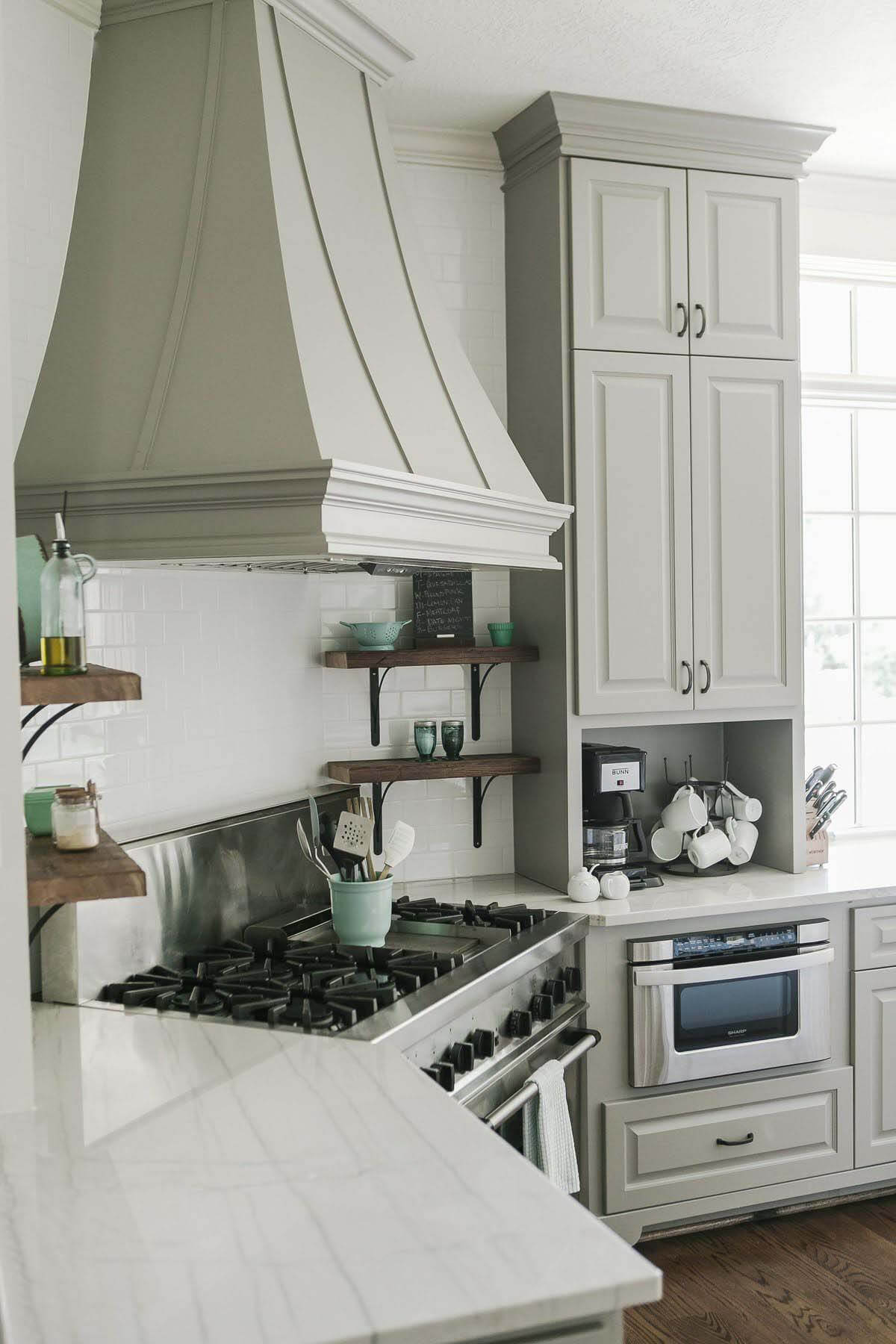 Hood stove in kitchen with gray cabinetry