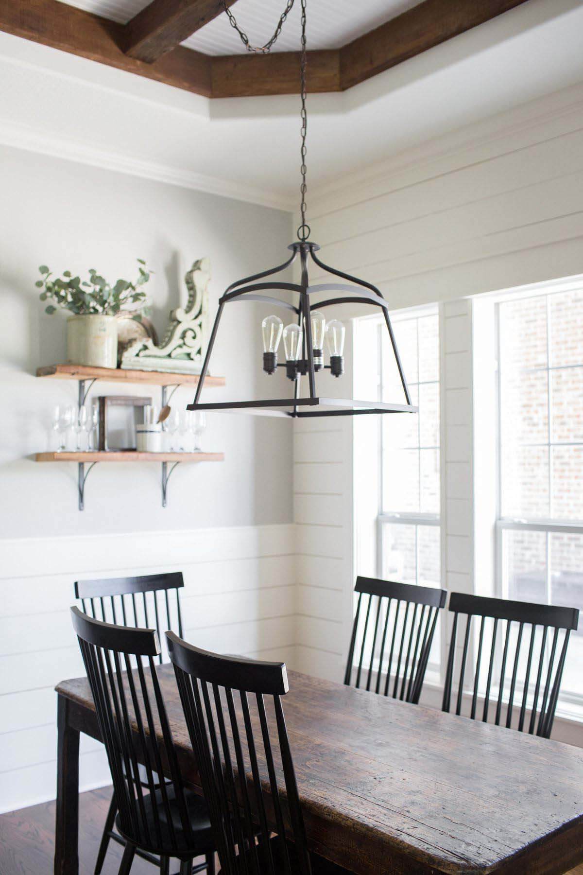 Dining table with light fixture and beamed ceiling