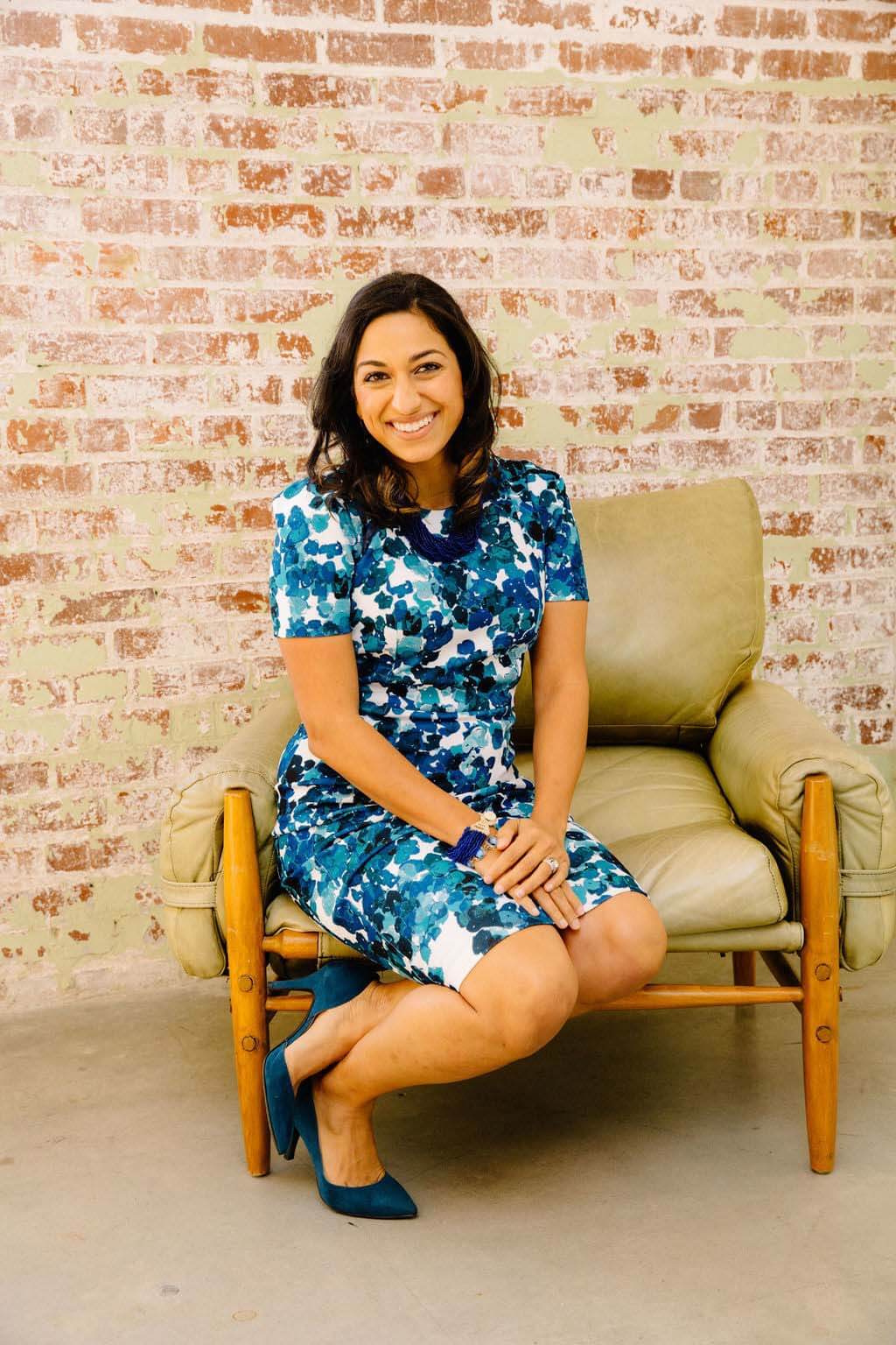 Fara Captain sitting in chair in front of a brick wall
