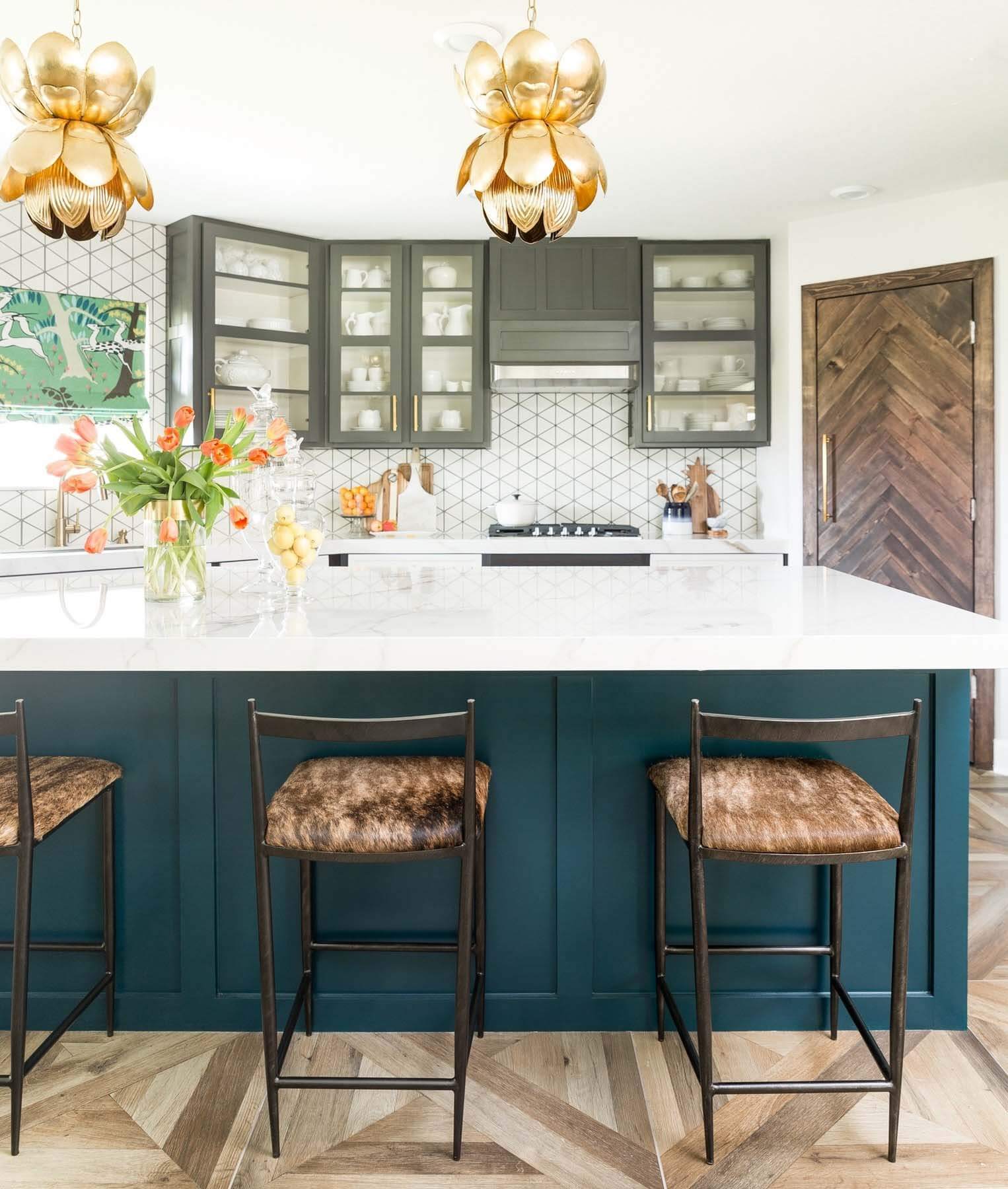 This kitchen renovation on a budget includes refreshed cabinets, new countertops, backsplash and flooring. The pendants are by Worlds Away with bar stools by Gabby Home. Kitchen renovation with refreshed cabinets