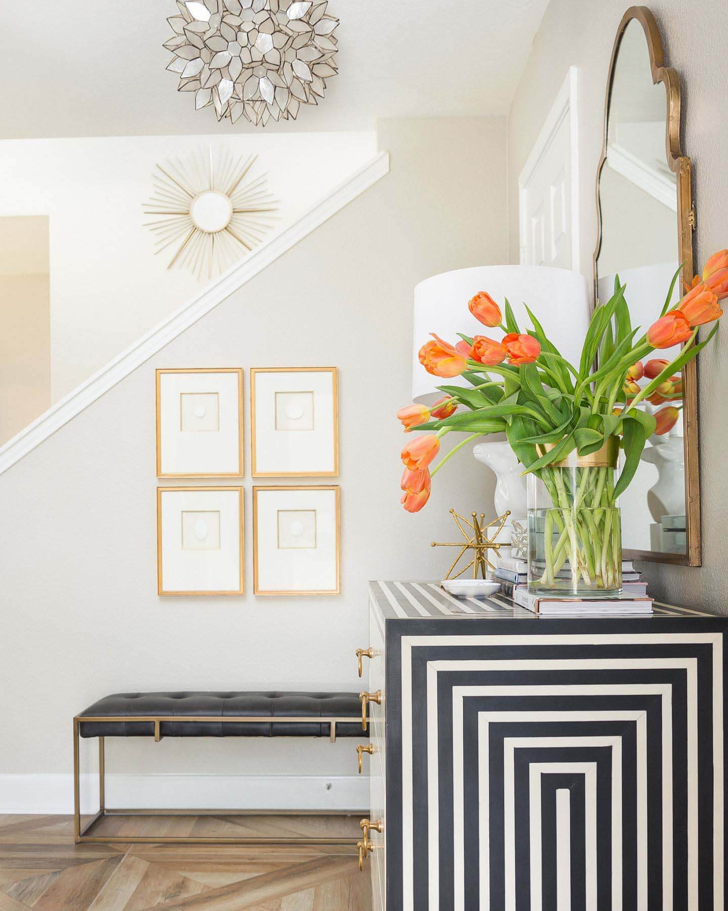 This memorable hallway benefits from an inlay chest by Worlds Away and a classic sunburst mirror. Hallway designed by Veronica Solomon
