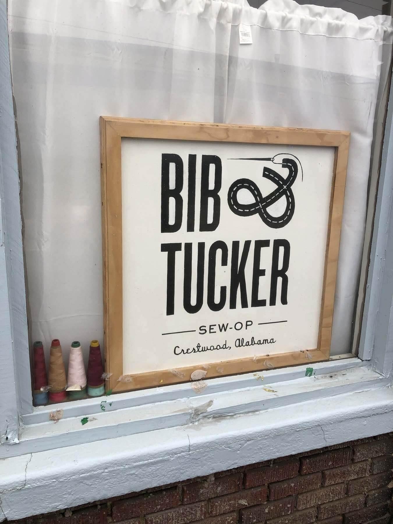 Wooden Bib & Tucker sign in window