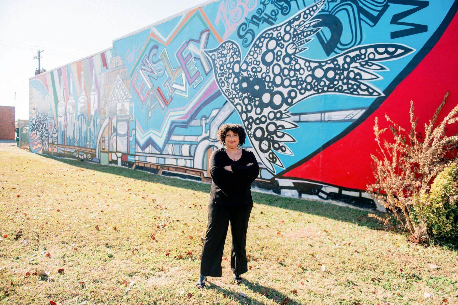 Bettina Byrd-Giles posing in front of Ensley Alive mural